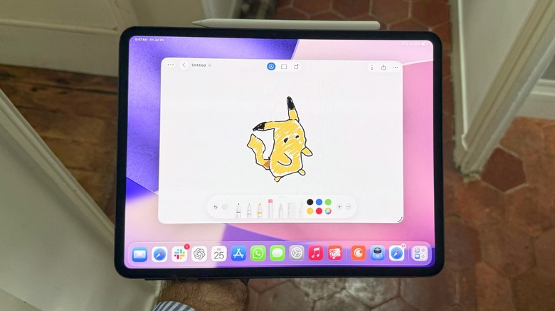A hand holding an iPad with a Pikachu doodled on it