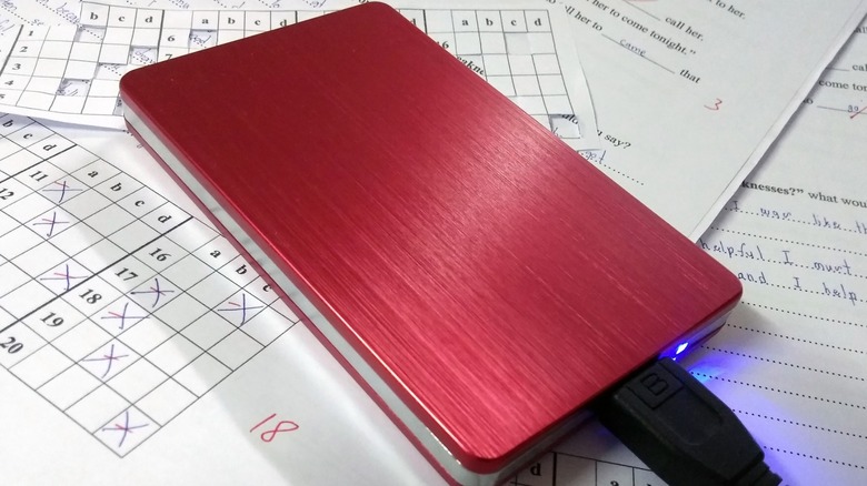 A red external hard drive sat on paper work