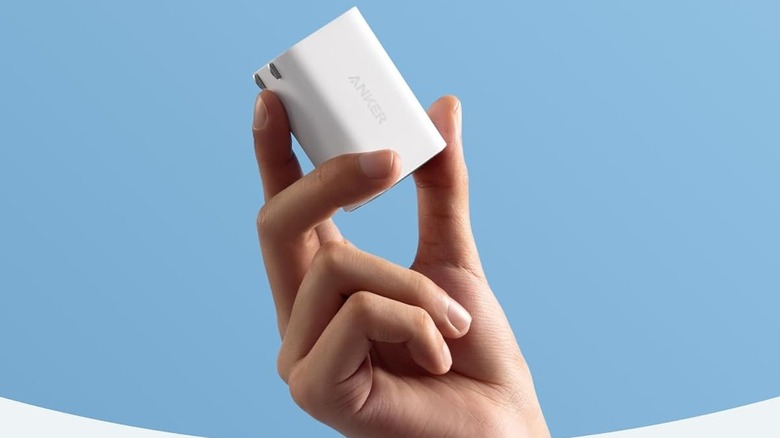 A hand holding an Anker Nano Laptop 100-watt Charger