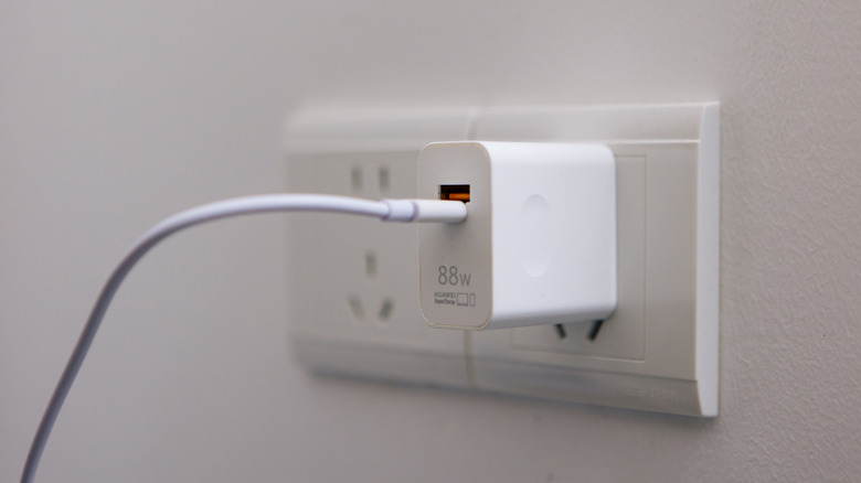 An 88-watt super fast charger plugged into a wall outlet
