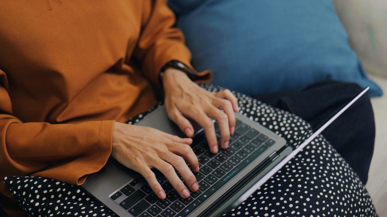 a woman using a laptop on her lap