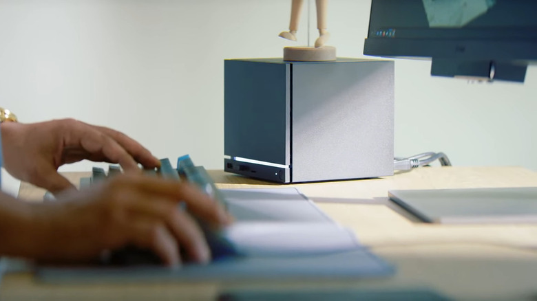Steam Machine sitting on a desk while someone types on a keyboard