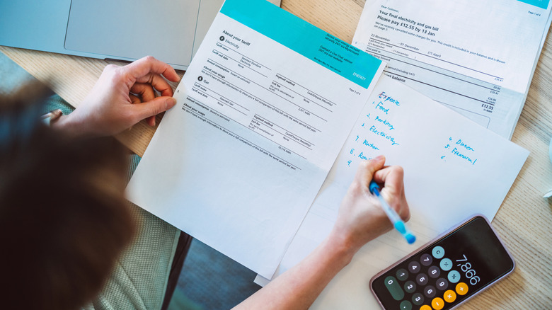 overhead view of woman working on paying off bills