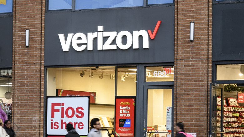 Verizon storefront, people walking in front of it