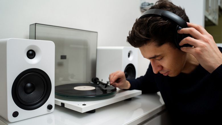An audiophile listening to a vinyl record on headphones