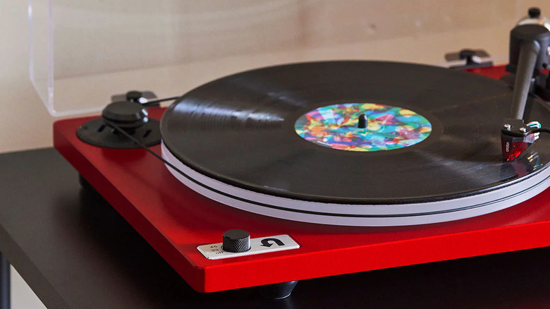 A red U-Turn Audio turntable playing a vinyl record