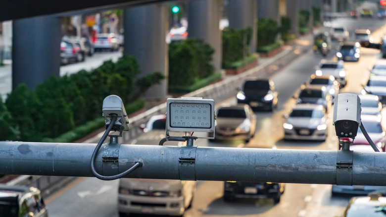 traffic cameras looking down on a busy street with cars and trucks in the background