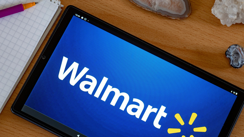 A Walmart tablet on a desk with notebook and geodes