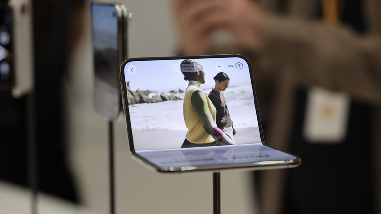 A folded iPhone Duo sits on a display during Apple's 