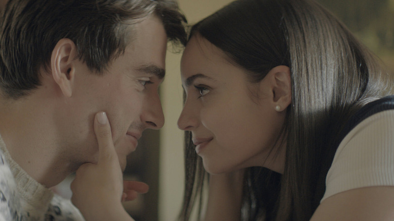 A young man and woman lean in close and look into each other's eyes