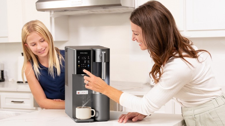 Two people using Waterdrop Filter's A2 Instant Hot Cold Water RO System on a counter