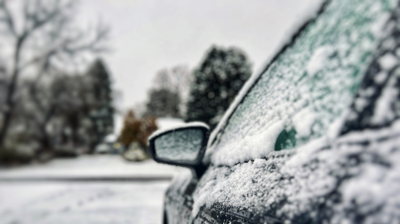 The front left door of a car covered in snow