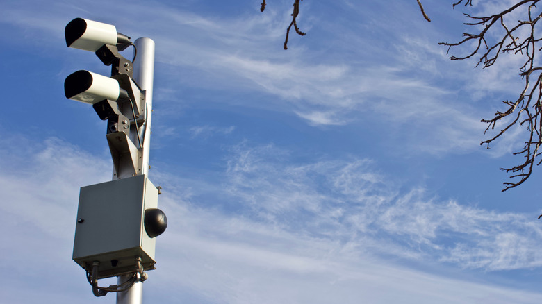 Two ALPR cameras mounted on a pole against a blue sky