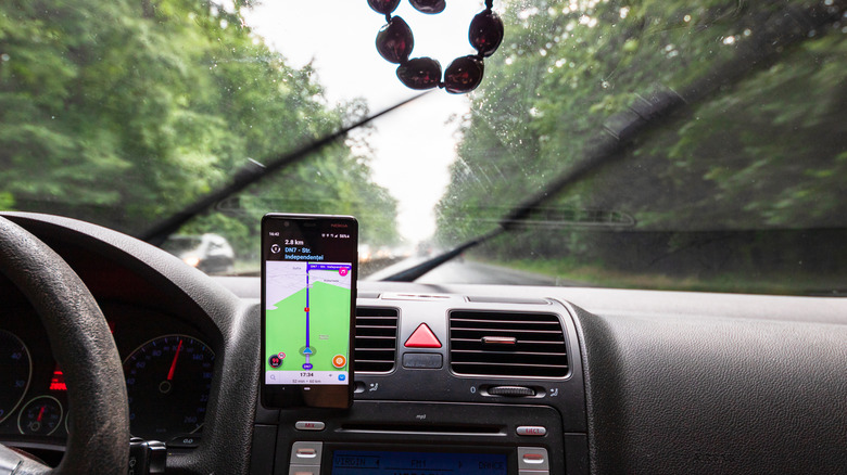 A Waze app showing navigation on in a car whose windshield wipers are going
