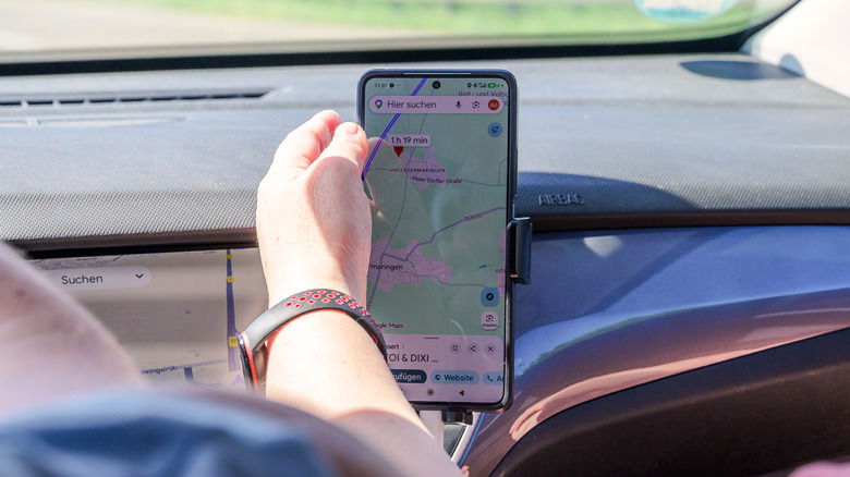 Phone mounted in car showing Google Maps