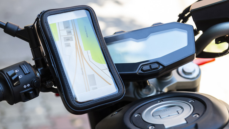 A navigation app on a phone attached to a motorcycle's handlebars.