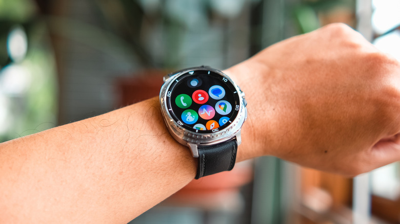 A smartwatch on someone's wrist displaying different app icons