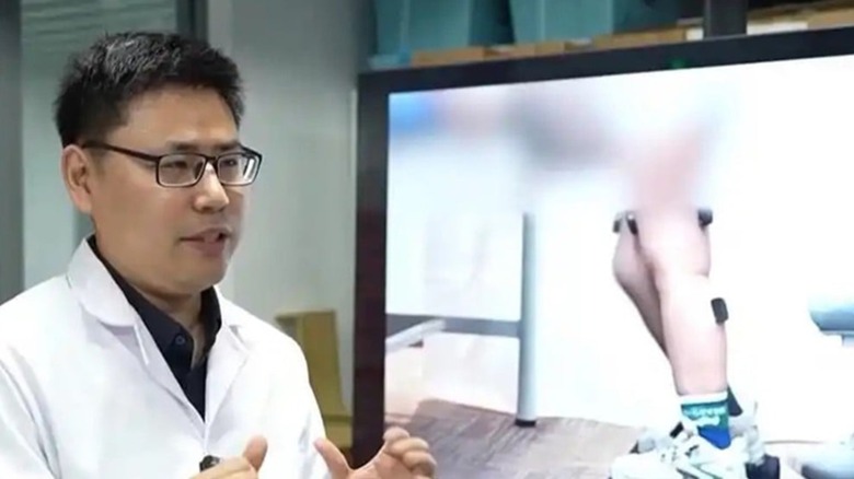 Feng Yanggang in front of a video showing the isokinetic training robot