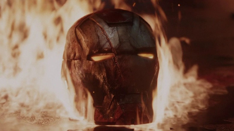 Iron Man's damaged helmet burning amid flames in Iron Man 3