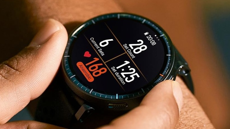 A person holding the sides of the Amazfit Active Max smartwatch.