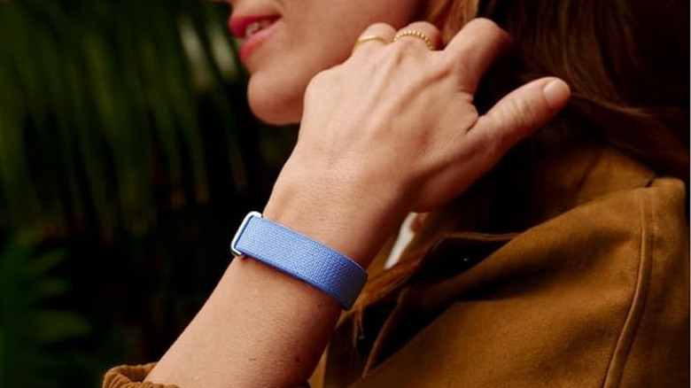 A person wearing the Google Fitbit Air fitness tracker on their wrist.