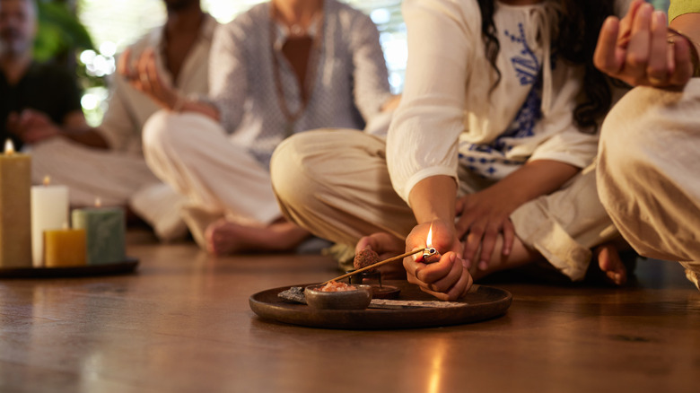 A woman meditating in the middle of a living room.