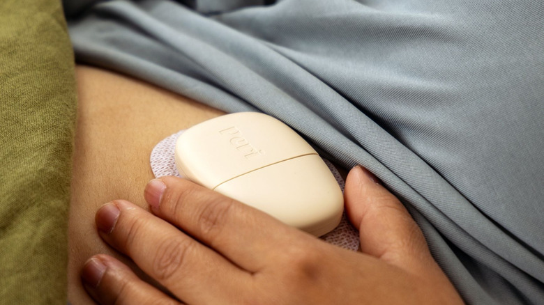 A woman with the Peri perimenopause tracker attached to her body.