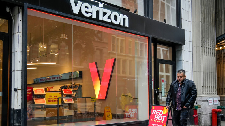 Verizon Wireless storefront with person walking by on street.