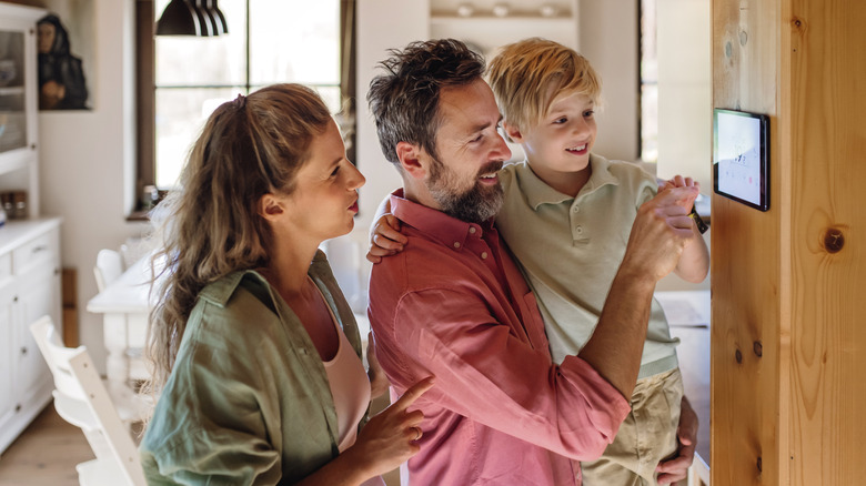 Family adjusting smart thermostat