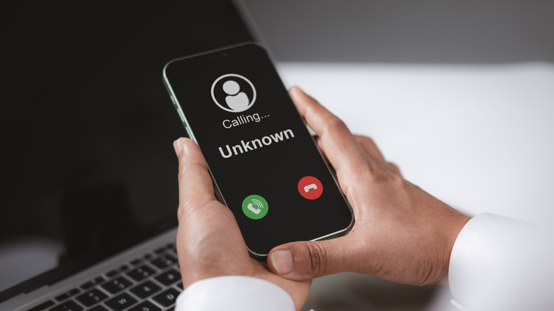 A phone shows an incoming call from an unknown number.