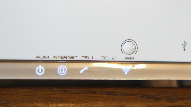 Close up view of a white router showing different LED symbols lit up