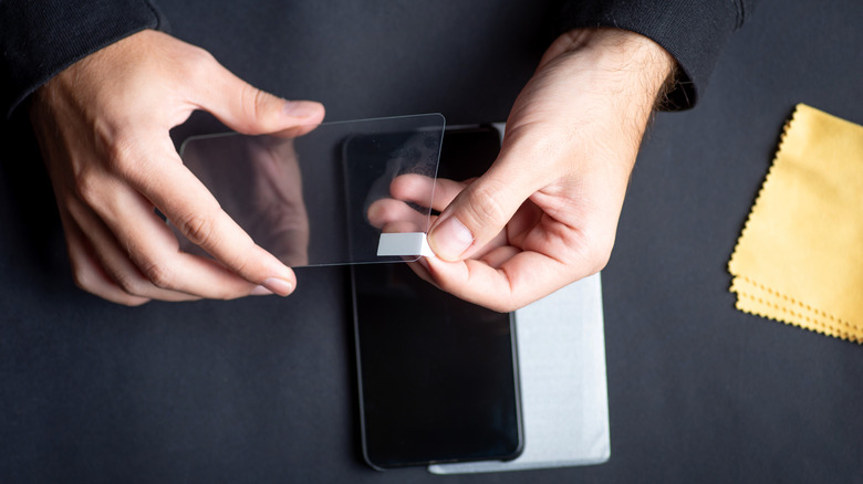 A screen protector being applied to a phone