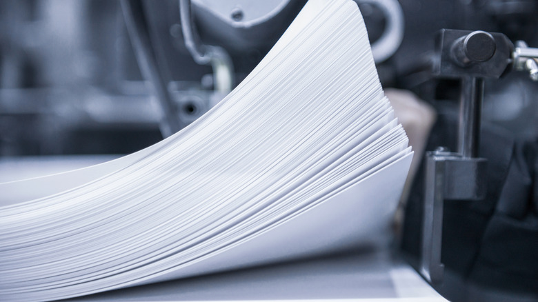 Close up of stack of paper being fed through a modern press.