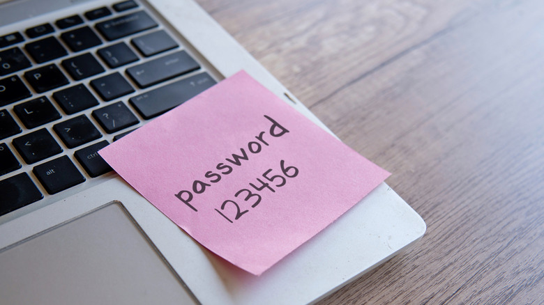 a sticky note on the edge of a laptop that says the password is 123456