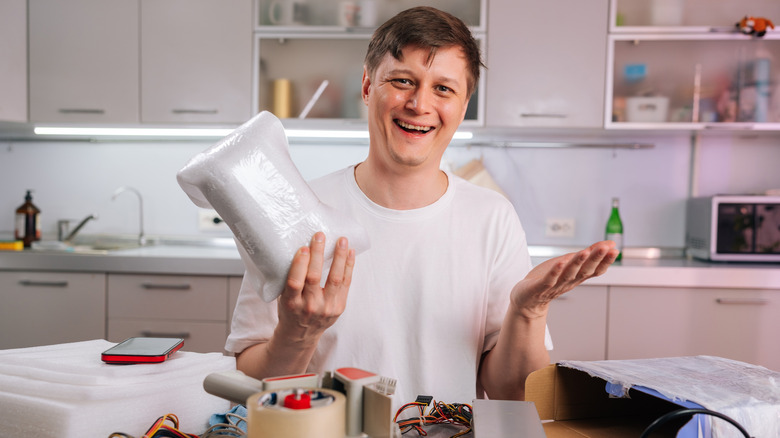 Man holding a PC component wrapped in shipping foam