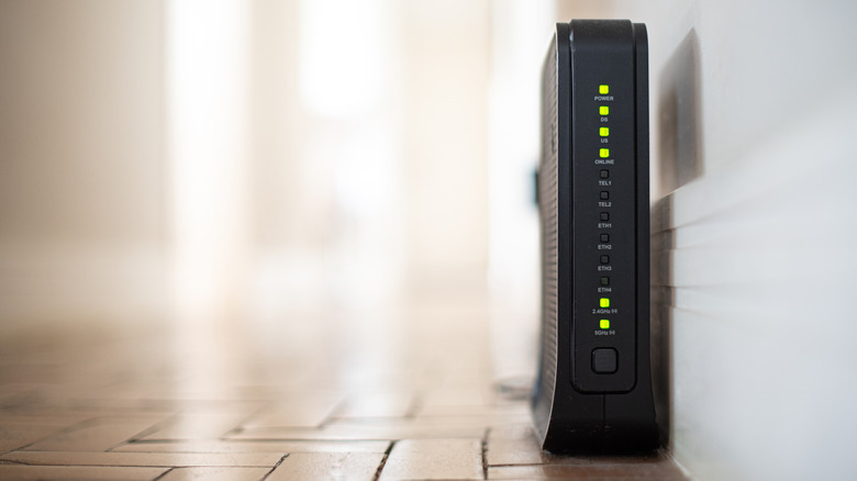 Close up of Wi-Fi router powered on and located on the floor