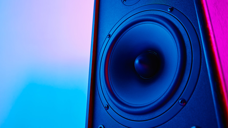 A close up of a speaker on a pink and blue backdrop.
