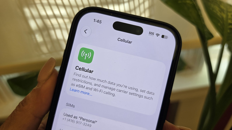 The top portion of an iPhone showing SOS and four dots beside the Wi-Fi and battery symbols