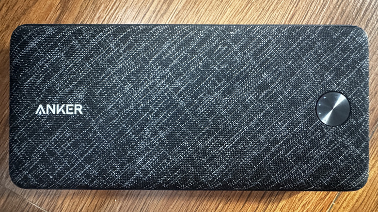 An Anker power bank showing battery indicator lights around the power button