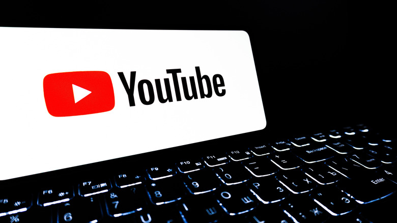YouTube logo on a phone while sitting on an computer keyboard