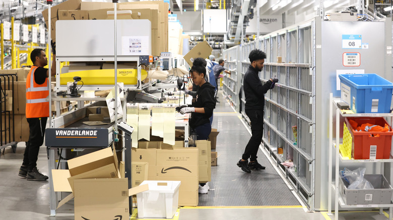 employees working at a amazon warehouse sorting packages
