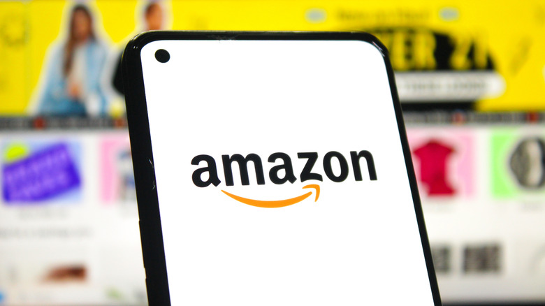 amazon logo on a smartphone with the amazon website in the background