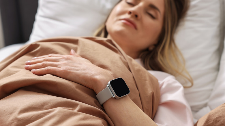 Woman sleeping with smart watch visible on her wrist