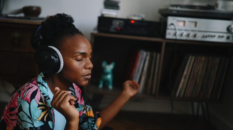 A woman listening to music with a pair of headphones.