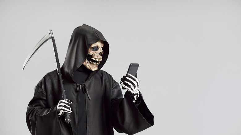 A grim reaper looking at a smartphone