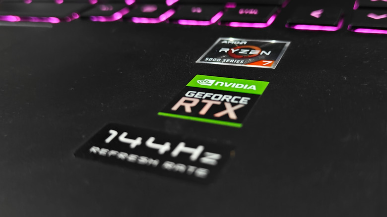 Stickers on a laptop showing AMD processor, Nvidia RTX, and 144Hz refresh rate