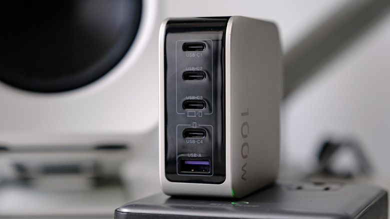 UGREEN X773 Nexode Pro 100W GaN charger with smart display shown during a desktop charging and technology setup session