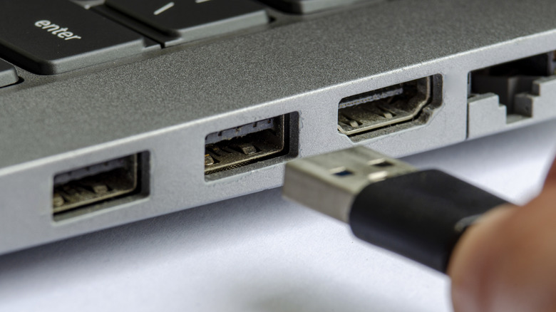 Zoomed in picture of a plug about to be inserted into a laptop's USB port