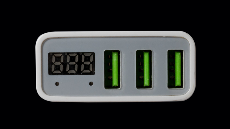 USB adapter for charging multiple mobile phones and modern devices on a black background.