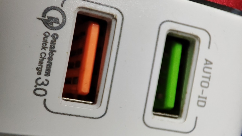 A red and green USB port side by side on a power charger.